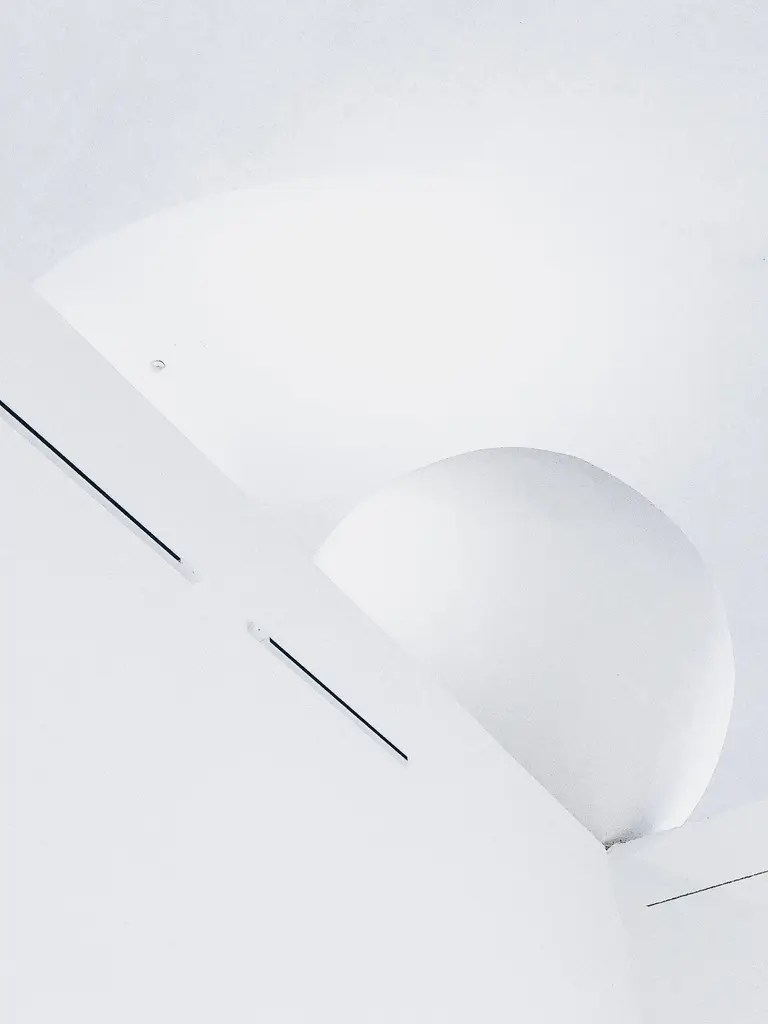An abstract white curved architectural detail with fine dark lines